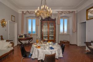 a dining room with a table and a chandelier at Villa Eugenia in Livorno
