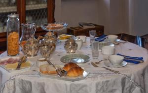 a table with a white table cloth with food on it at Villa Eugenia in Livorno