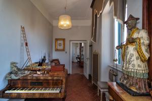 a room with a statue of a man standing next to a piano at Villa Eugenia in Livorno