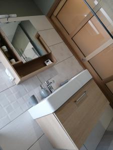 La salle de bains est pourvue d'un lavabo et d'un miroir. dans l'établissement les Pénates appartement terrasse, à Saint-Max