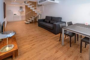 salon z kanapą i stołem w obiekcie Apartments Playa de Castelldefels w mieście Castelldefels