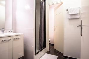 a white bathroom with a sink and a shower at Hotel Actuel Chambéry Centre Gare in Chambéry +16 photos