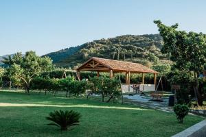a pavilion in a park with a mountain in the background at Valle degli Agrumi in San Pier Niceto