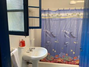 a bathroom with a sink and a shower curtain with dolphins at El Palacio in Choachí