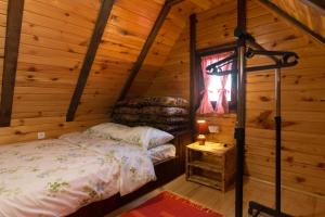 a bedroom with a bed in a log cabin at Brvnara na bregu in Bajina Bašta