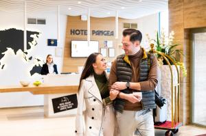 mężczyzna i kobieta przechodzący przez hol hotelowy w obiekcie Pangea Hotel w Nyíregyházie