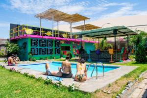 een groep mensen die in een zwembad zitten bij The Upcycled Hostel Huacachina in Ica