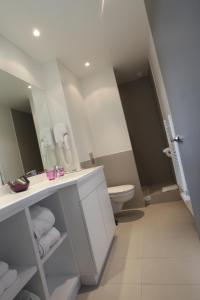 W łazience znajduje się umywalka, toaleta i lustro. w obiekcie Hotel 202 w mieście Soorts-Hossegor