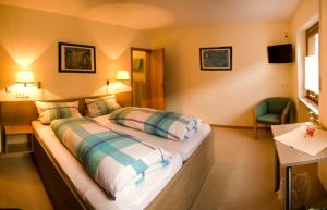 a hotel room with a bed and a chair at Kühn's Gästehaus in Pünderich