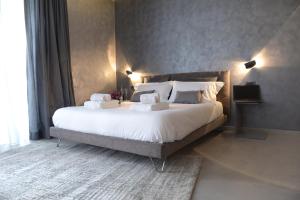 a bedroom with a large bed with white sheets and pillows at suite28 in Brindisi