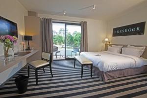 um quarto de hotel com uma cama, uma mesa e cadeiras em Hotel 202 em Hossegor