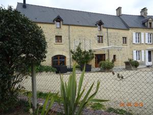 a large building with a fence in front of it at La ferme aux chats in Formigny