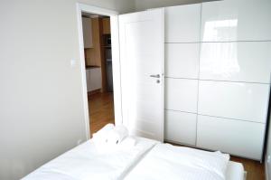 um quarto branco com uma cama e um closet em Apartament , Bałtycka 11 em Kolobrzeg