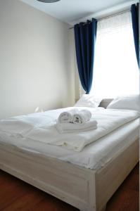 uma cama branca com toalhas e uma janela em Apartament , Bałtycka 11 em Kolobrzeg
