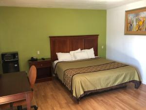 a hotel room with a bed and a desk at Americas Best Value Inn Visalia in Visalia +14 photos