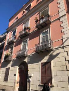 um edifício com duas pessoas à frente dele em Vanvitelli's Home em Caserta
