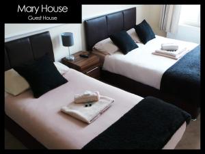 two beds in a hotel room with towels on them at Mary House 46 in Porthcawl