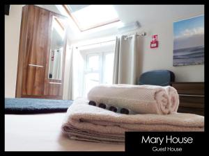 a bedroom with a bed with a blanket and a window at Mary House 46 in Porthcawl