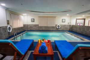 a large swimming pool with a table in front of it at Gloria Inn Riyadh in Riyadh