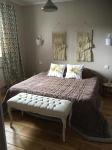 a bedroom with a large bed with a bench on it at B&B Les Hauts d'Ornans in Ornans +23 photos