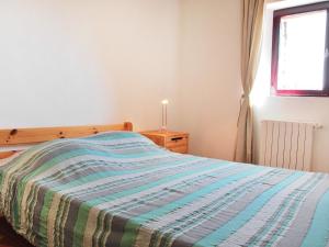 a bedroom with a bed with a striped blanket at Holiday Home Les Geais by Interhome in Saint-Saturnin-les-Apt