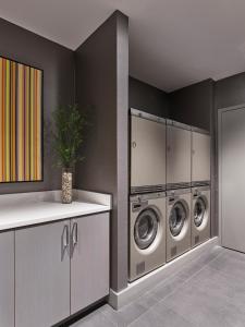 a laundry room with three washing machines in it at AKA Rittenhouse Square in Philadelphia