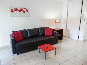 a living room with a black couch and a red table at Apartment Le Kappas in Nice