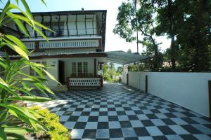 a house with a black and white checkered floor at Gokulam Home Stay in Munnar