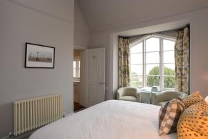 a bedroom with a bed and a window and a table at Crown and Castle in Orford