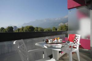 d'une table et de chaises sur un balcon avec vue. dans l'établissement The Originals City, Hôtel Villancourt, Grenoble Sud (Inter-Hotel), à Le Pont-de-Claix