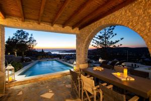 an outdoor patio with a table and a swimming pool at Villa Haritomeni in Parikia