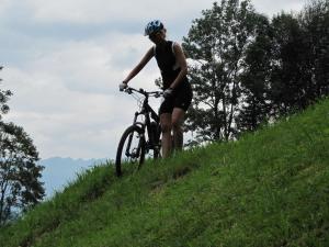 una mujer montando una bicicleta por una colina en Ferienwohnungen Kröll, en Schwendau