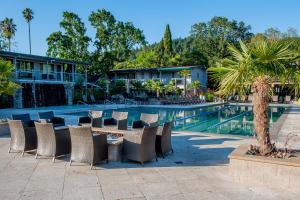 a resort with a pool with chairs and a hotel at Calistoga Spa Hot Springs - Authentic Hot Springs Spa & Resort in Calistoga