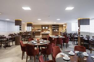 une salle à manger avec des tables et des chaises dans un restaurant dans l'établissement Hotel Fioreze Primo - 800m da Rua Coberta, à Gramado