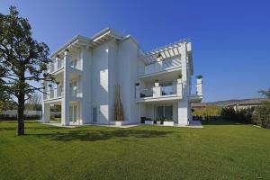 a large white house with a lawn in front of it at Villa Bianca Luxury Apartments in Desenzano del Garda