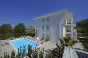 a large building with a swimming pool next to a building at Villa Bianca Luxury Apartments in Desenzano del Garda