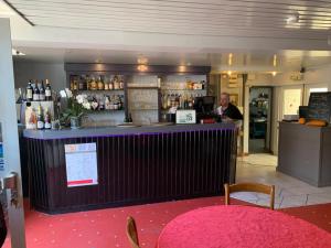 a man standing at a bar in a restaurant at L'Escale in Longeau