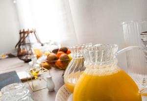 a table with a jug of orange juice and a bowl of fruit at Garda Room in Peschiera del Garda