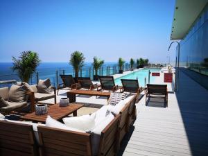 a row of chairs and tables on a balcony with a pool at Apartamento de Lujo. Frente Mall Plaza in Antofagasta