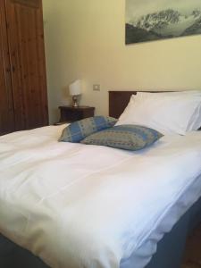 un grande letto bianco con due cuscini sopra di Hotel Belvedere Dolomiti a Pieve di Cadore