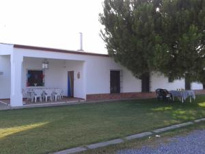 um edifício branco com mesas e cadeiras num quintal em Casa rural la noria em Los Palacios y Villafranca