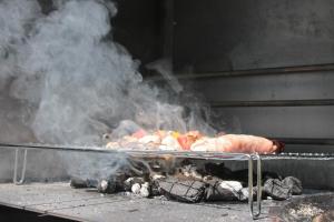 a grill with a bunch of meat and smoke at Locanda Dei Baroni - Antica Dimora in Camaldoli
