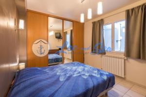 ein Schlafzimmer mit einem blauen Bett und einem Spiegel in der Unterkunft Maison Flamants Roses avec Piscine in Le Grau-du-Roi