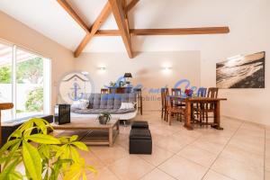 ein Wohnzimmer mit einem Sofa und einem Tisch in der Unterkunft Maison Flamants Roses avec Piscine in Le Grau-du-Roi