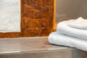 un montón de toallas sentadas en un mostrador en un baño en Gottwalds Inn en Obernburg am Main
