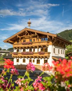 een groot gebouw met bloemen ervoor bij Appartemets Hauserbauer in Kaprun