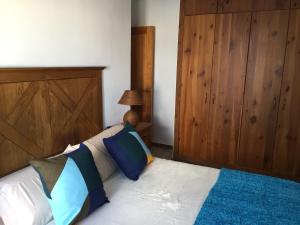 a bedroom with a bed with a wooden headboard at Apartamento situado en el centro de Santa Cruz in Santa Cruz de Tenerife