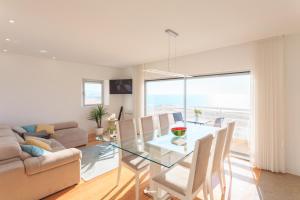 a living room with a glass table and a couch at Nazare Marisol Praia in Nazaré