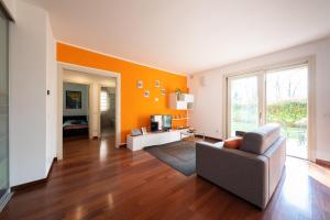 un soggiorno con divano e parete arancione di Oasi a Bergamo