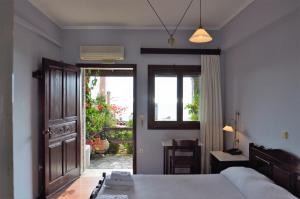 Schlafzimmer mit einem Bett und einer Tür zu einer Terrasse in der Unterkunft Ilion Hotel in Nafpaktos